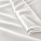 Lichtgrijze Jatasch stof met subtiele satijnglans, matte afwerking en elegante plooien voor comfortabel antibacterieel beddengoed.