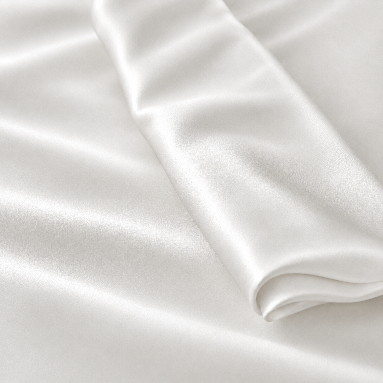 Lichtgrijze Jatasch stof met subtiele satijnglans, matte afwerking en elegante plooien voor comfortabel antibacterieel beddengoed.